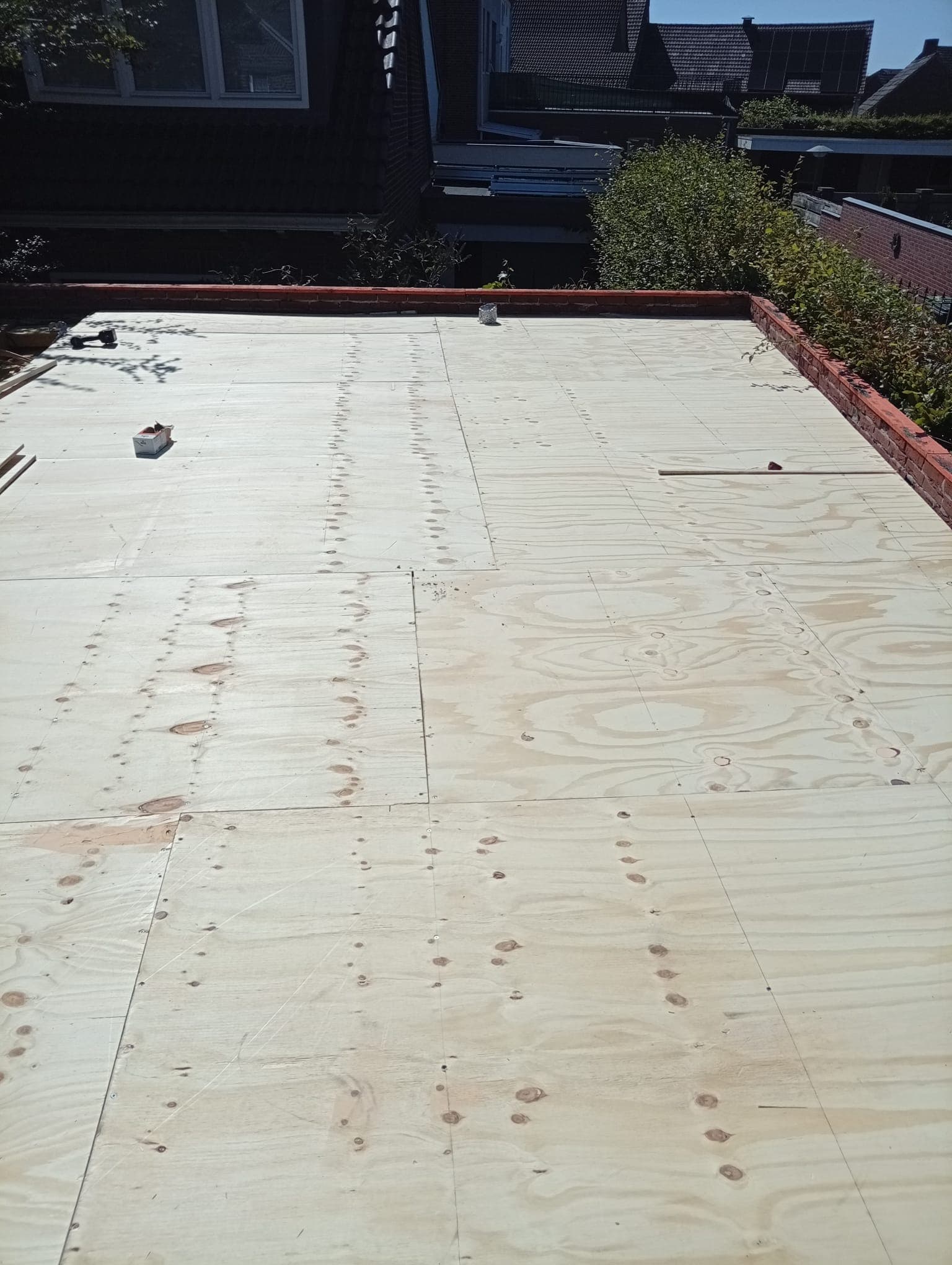Nieuwe houten dakvloer tijdens een renovatie van een plat dak