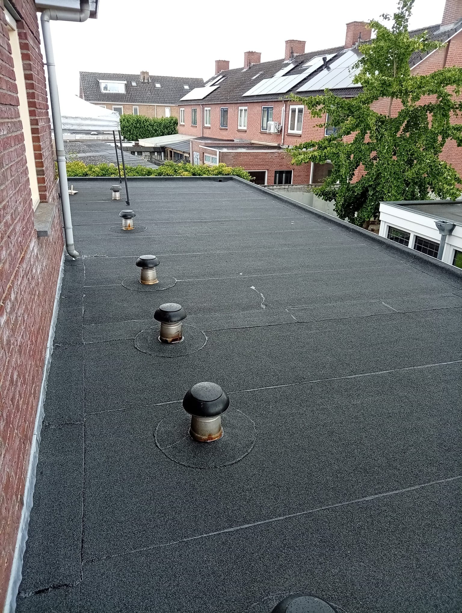 Plat bitumen dak tussen woningen in een stedelijke omgeving